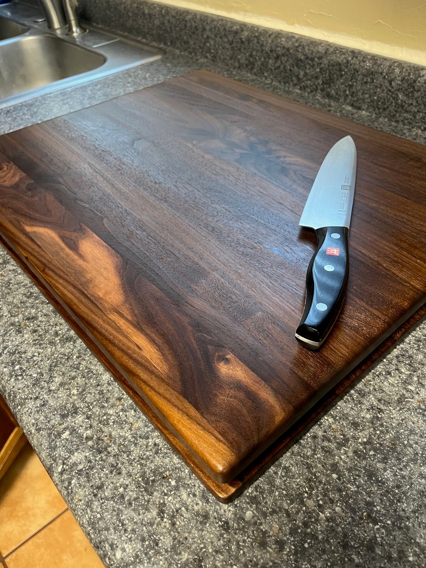 20"X16-1/4"X2" Walnut Edge Grain Cutting Board with unique hand all the way around the edges. No rubber feet.